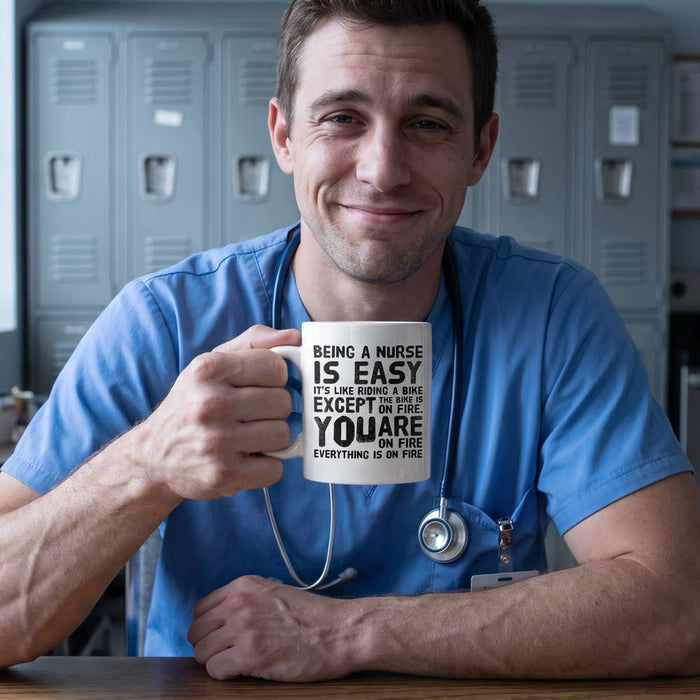 Male nurse in blue scrubs holding a funny nurse gift mug that reads Being a Nurse Is Easy in a hospital break room