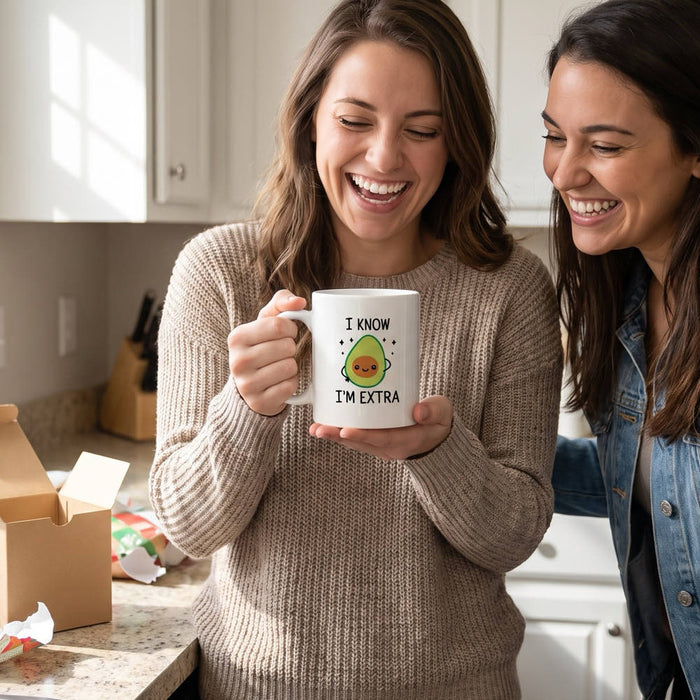 Two friends laughing at the I KNOW I'M EXTRA avocado mug, a funny vegan present just unwrapped