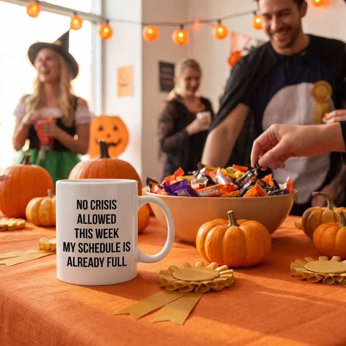 Office Halloween party prize table with a No Crisis Allowed This Week mug, pumpkins, candy and gold ribbon rosettes