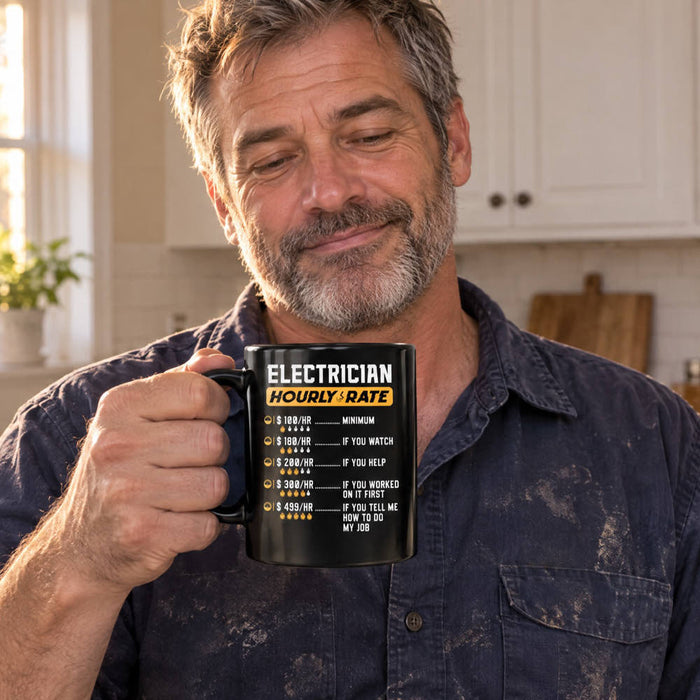 Funny electrician gifts: an electrician in a kitchen holding the Electrician Hourly Rate mug